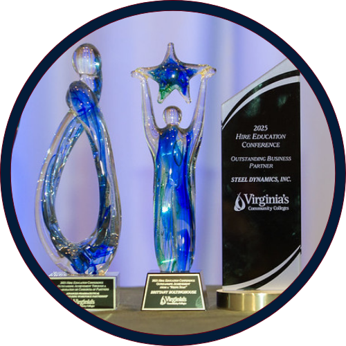 Three glass awards displayed on a table, including a star-shaped recognition award and a Virginia’s Community Colleges Outstanding Business Partner plaque.